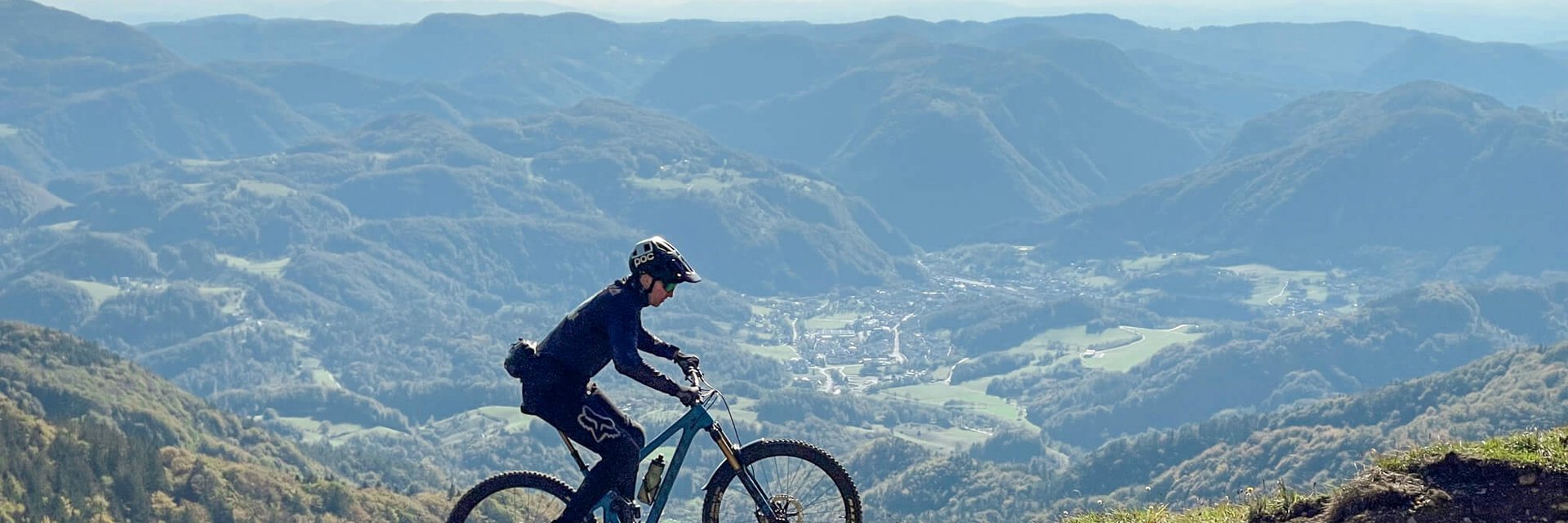 Mountainbiker rijdt op een pad met bergen en vallei op de achtergrond
