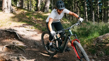 Mit Martina & Flo zum Mountainbiken im LifeSport Hotel Hechenmoos © Martina Wunderle / Flo Distl Frau fährt Mountainbike auf einem Waldweg mit Wurzeln und Steinen
