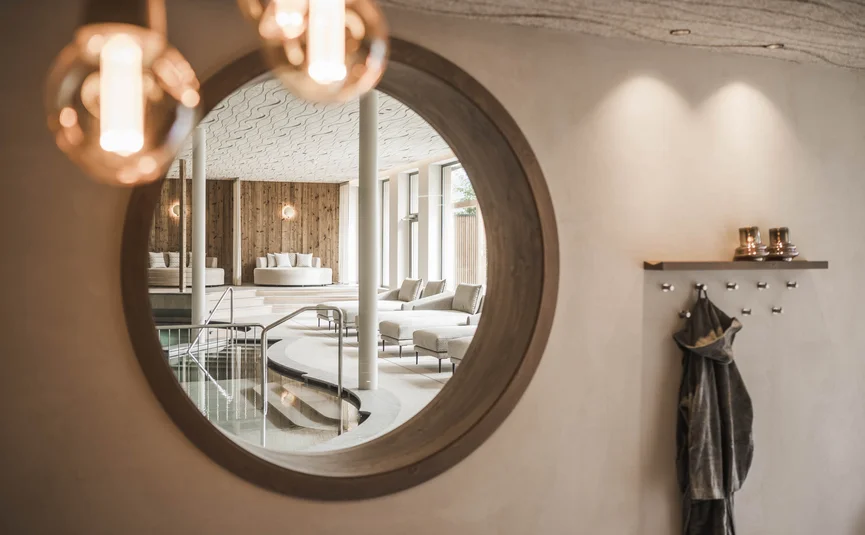 Mirror reflecting a modern spa area with pool and lounge chairs