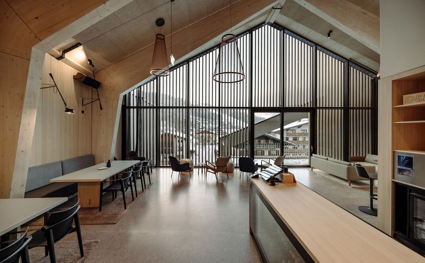 Modern living room with large windows and chairs overlooking snowy landscape