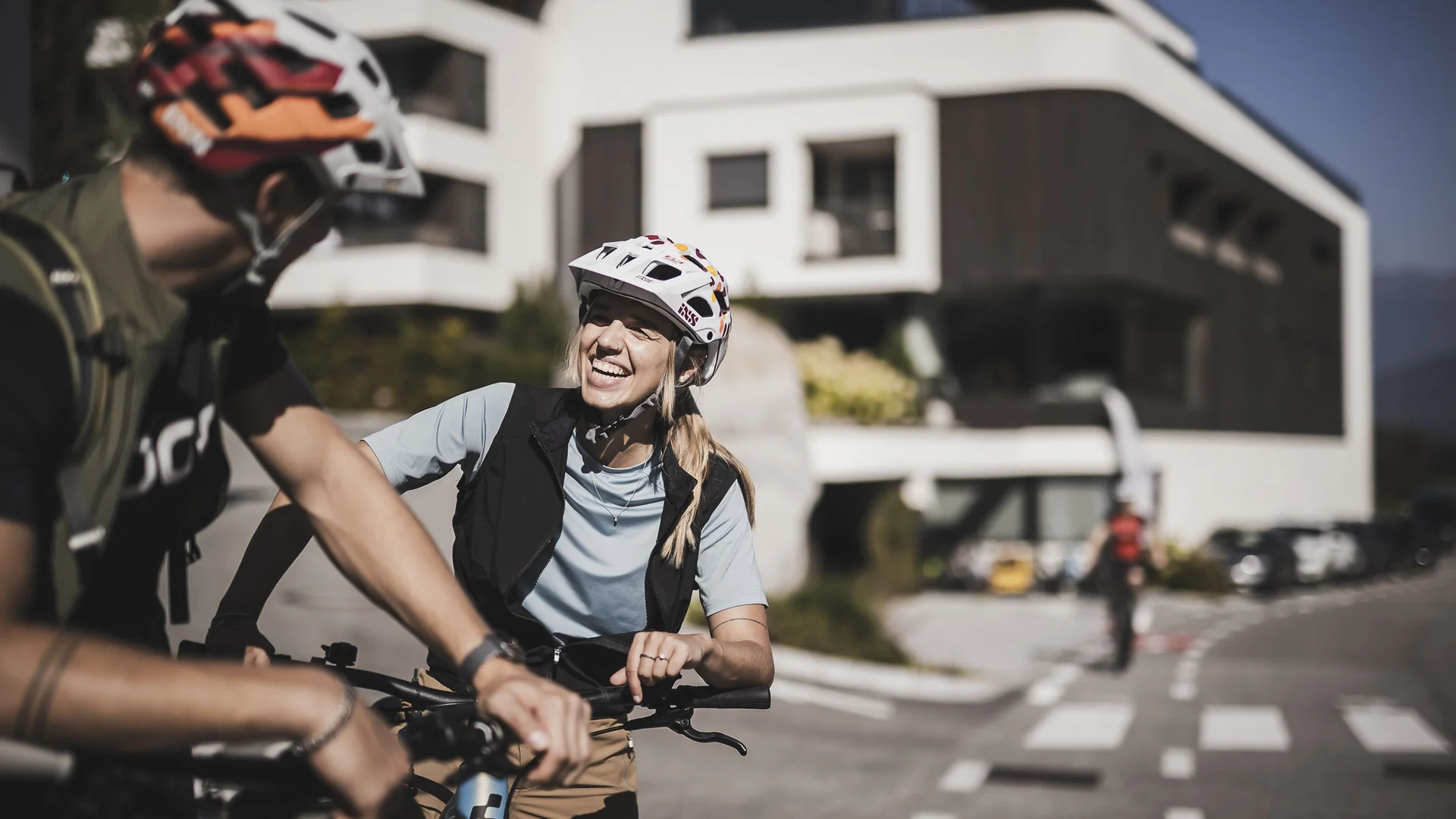 Mountainbike-Saisonstart am Kronplatz © Kottersteger Frau und Mann mit Fahrradhelmen lachen draußen an einem sonnigen Tag