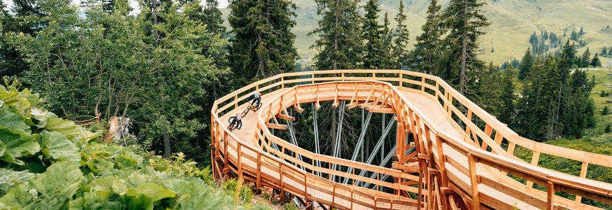 Fahrradfahrer auf einer Holzspiralstrecke im Bergwald