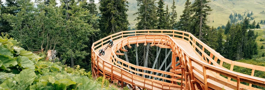 Fahrradfahrer auf einer Holzspiralstrecke im Bergwald