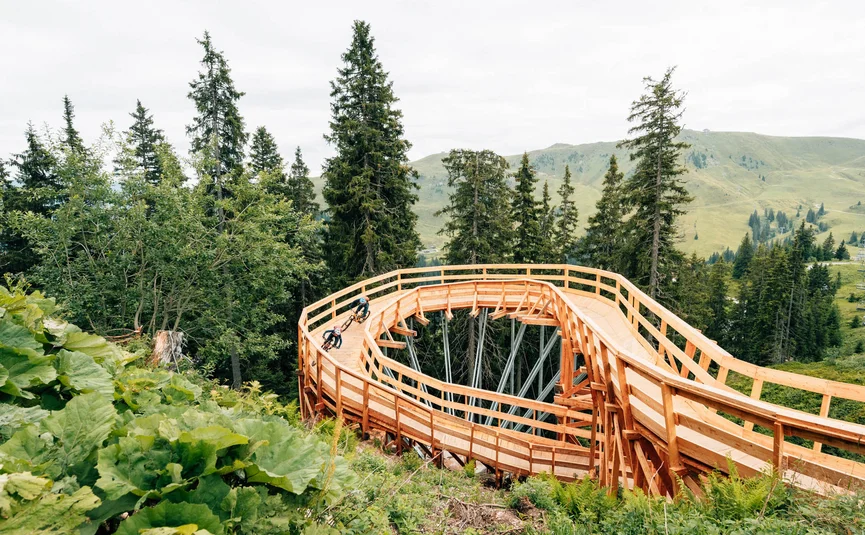 Fahrradfahrer auf einer Holzspiralstrecke im Bergwald