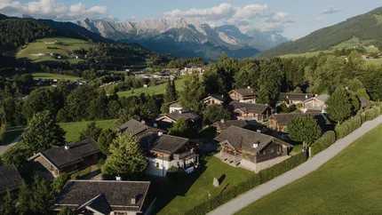 Puradies - Saalfelden: Bergmagie en panoramaweg © Lukas Reschreiter Dorp met houten huizen en bergen op de achtergrond bij zonnig weer