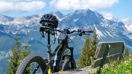 Mountainbike met helm op bank voor berglandschap