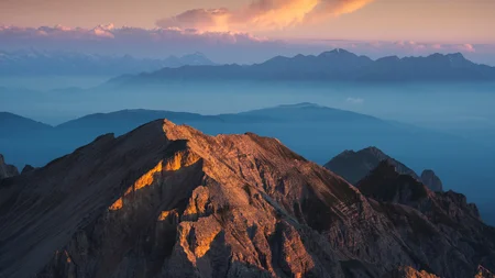 Ein Herbst-Wochenende in San Vigilio © Bruno Pisani / San Vigilio Dolomites Sonnenuntergang beleuchtet Berggipfel mit nebelverhüllten Bergen im Hintergrund
