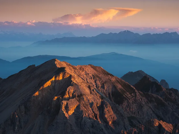Ein Herbst-Wochenende in San Vigilio © Bruno Pisani / San Vigilio Dolomites Sonnenuntergang beleuchtet Berggipfel mit nebelverhüllten Bergen im Hintergrund