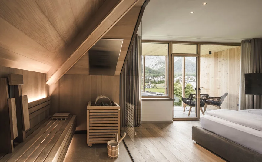 Sauna with glass wall beside bedroom and balcony with mountain view