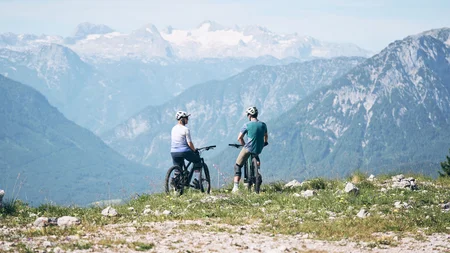 Ein perfekter Enduro-Tag – vom ersten Höhenmeter bis zum letzten Trail © Tobias Köhler Zwei Radfahrer mit Helmen blicken auf Berge und Schnee im Hintergrund