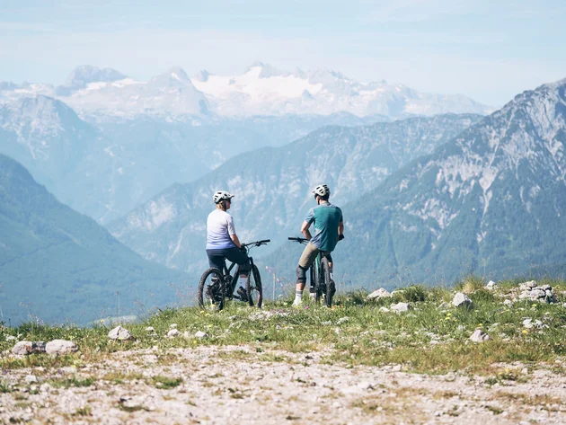 Ein perfekter Enduro-Tag – vom ersten Höhenmeter bis zum letzten Trail © Tobias Köhler Zwei Radfahrer mit Helmen blicken auf Berge und Schnee im Hintergrund
