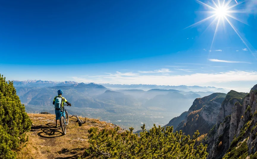 Mountainbiker auf Gipfel mit Panoramablick auf Berge und Tal