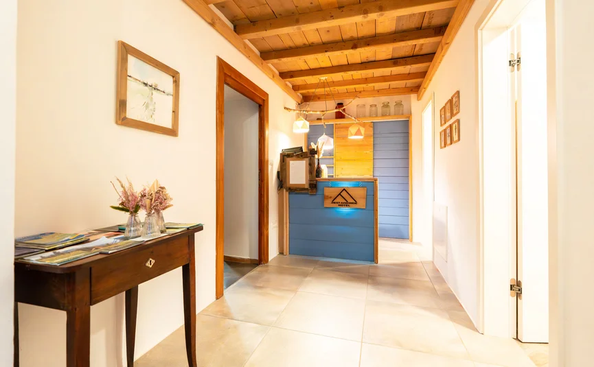 Hotelgang met blauwe receptiebalie en houten balkenplafond