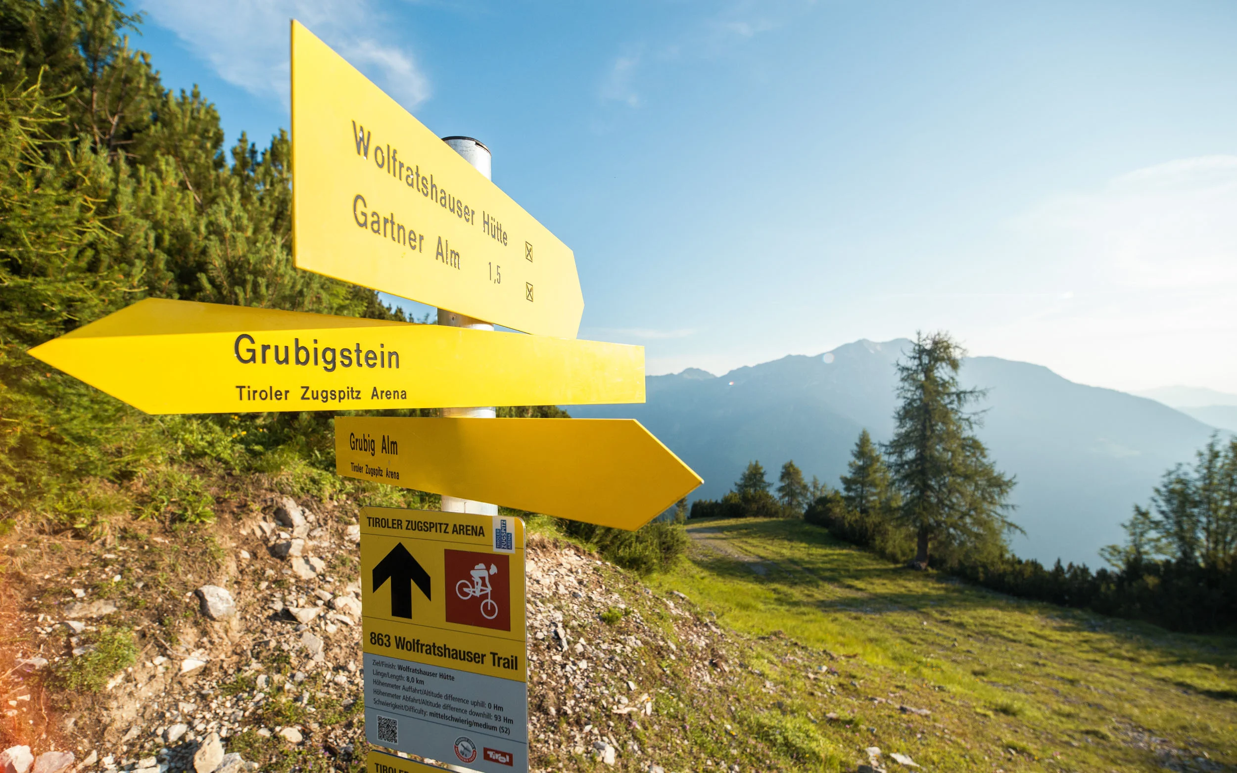 Gelbe Wanderwegweiser im Tiroler Zugspitzgebiet mit Bergblick