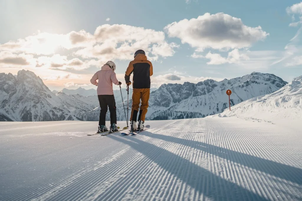 Zugspitze Schönruh Superski & Sonnenski Wochen 2027 Zwei Skifahrer auf einer präparierten Piste vor verschneiten Bergen