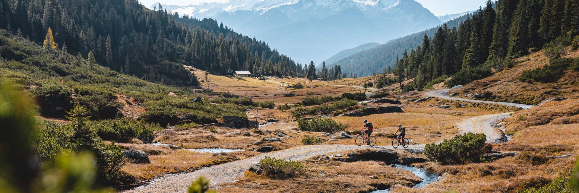 Alpenhotel Landhaus Küchl *** © TVB Kitzbüheler Alpen - Brixental - Mathäus Gartner Two cyclists on a mountain trail with snow-capped peaks in the background