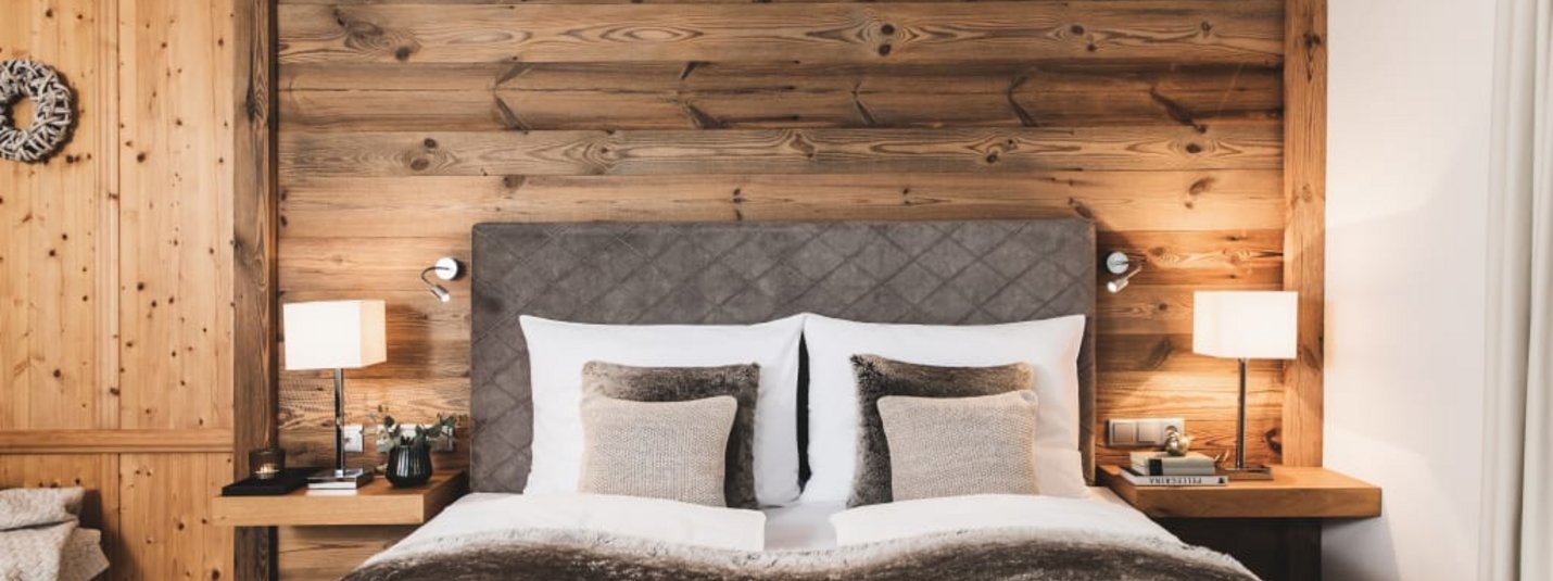 Cozy bedroom with wood paneling and soft pillows