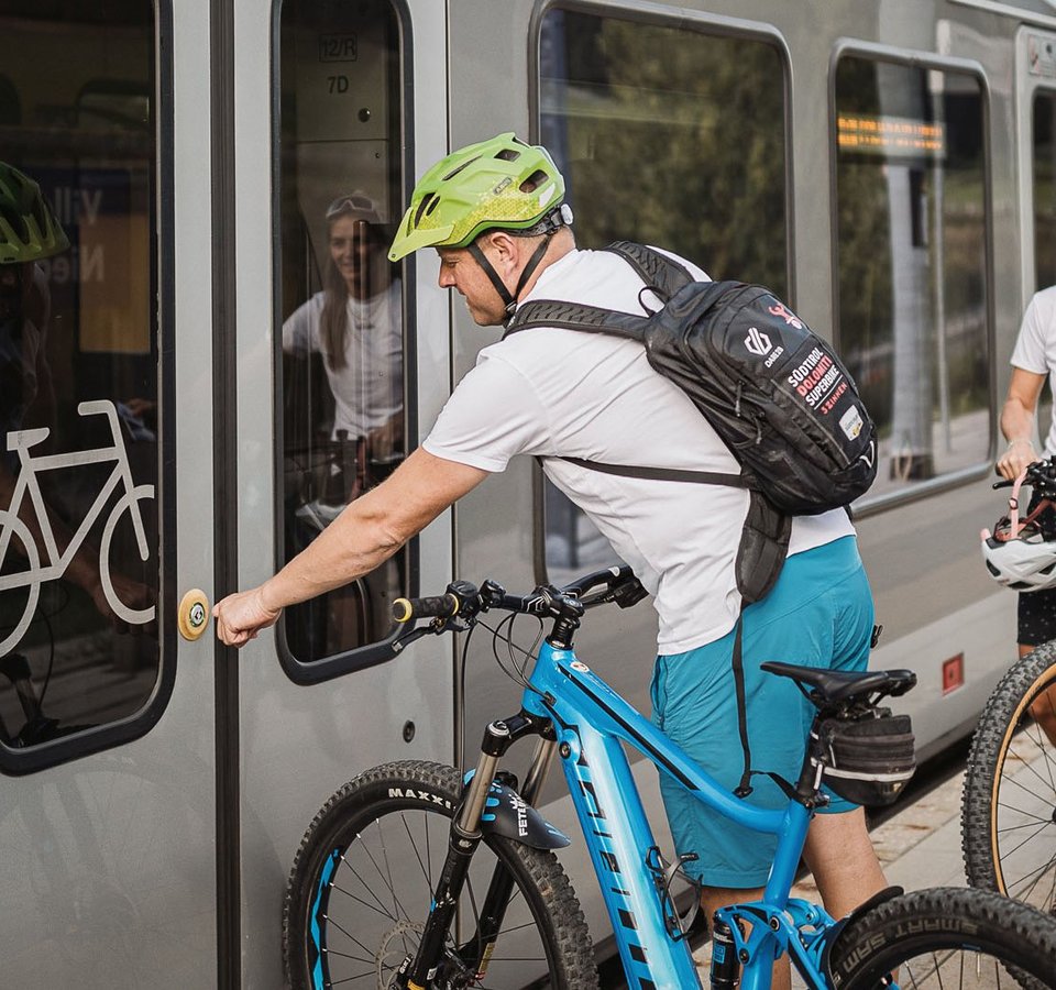 Personen mit Fahrrädern warten auf Zug mit Fahrradabteil