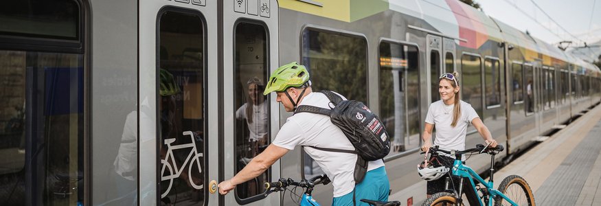 Personen mit Fahrrädern warten auf Zug mit Fahrradabteil