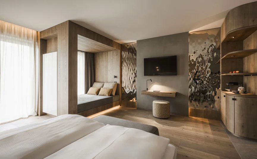 Modern hotel room with wooden furniture and cozy seating area