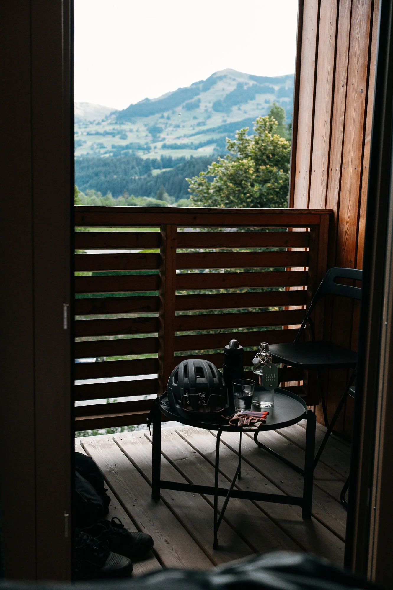 Mit Martina & Flo zum Mountainbiken im LifeSport Hotel Hechenmoos © Martina Wunderle / Flo Distl Balkon mit Bergblick, Tisch mit Fahrradhelm, Flasche und Glas