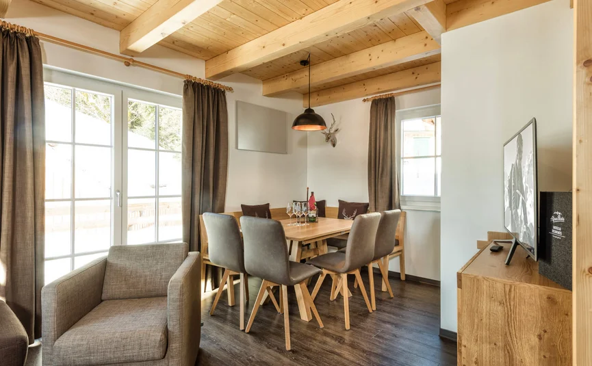 Gezellige eetruimte met houten plafond, tafel, stoelen en groot raam