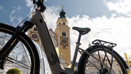 Das war die bike festa Südtirol in Brixen © Brixen Tourismus - Bike vor dem Dom Brixen Fahrrad vor einem gelb-weißen Kirchturm mit Zifferblättern unter blauem Himmel