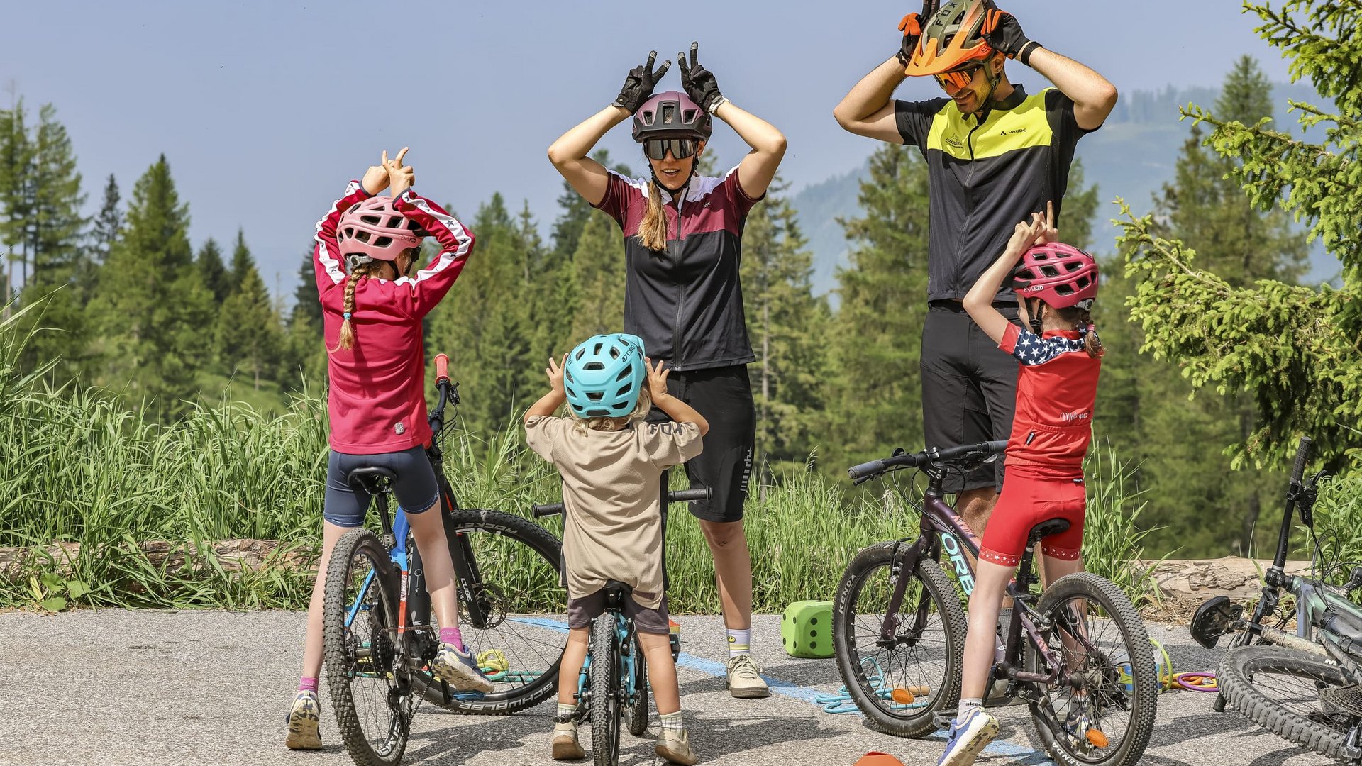 Familie macht Radfahrübungen draußen in den Bergen