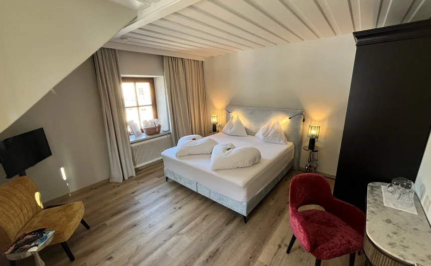 Modernes Hotelzimmer mit Doppelbett und Sitzbereich