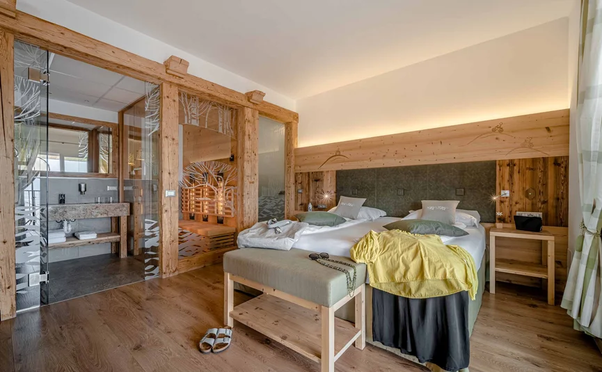 Cozy hotel room with double bed and glass-enclosed sauna