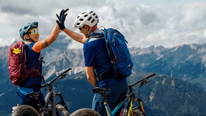 Mountainbike Urlaub für Anfänger
© David Karg Zwei Mountainbiker geben sich auf einem Berggipfel abklatschend die Hand