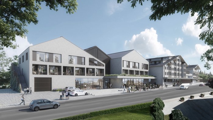 MTB in der DNA: Bikesommer im DIPS&DROPS © Matthias Warter Moderne Gebäude mit Parkplätzen und Menschen auf Gehweg an sonnigem Tag