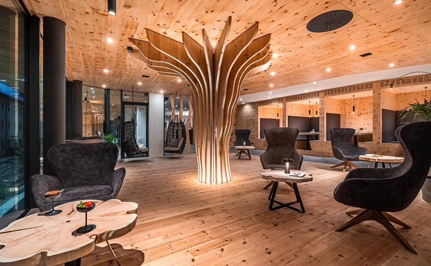 Modern lounge with wooden ceiling, designer chairs, and artistic wooden pillar