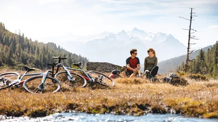 Zwei Radfahrer machen Pause in den Bergen neben ihren Fahrrädern