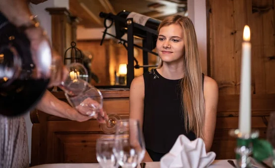 Winemaker on the mountain summer & autmun - 2 nights Waiter pouring water into a glass for a woman in a rustic restaurant