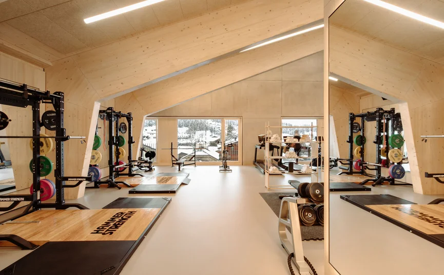 Lichte sportschool met houten wanden en gewichten voor grote ramen