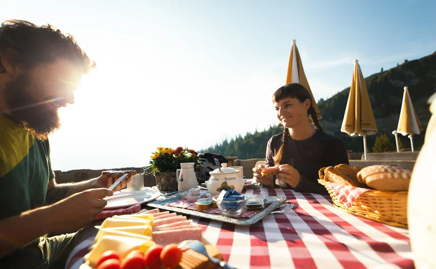 Couple enjoying outdoor breakfast in sunny mountain weather