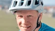 Mann mit blauem Shirt und weißem Fahrradhelm im Freien