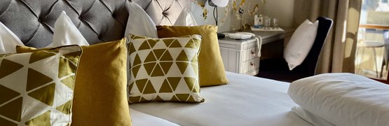Elegantes Hotelzimmer mit gemütlichem Doppelbett und dekorativen Kissen