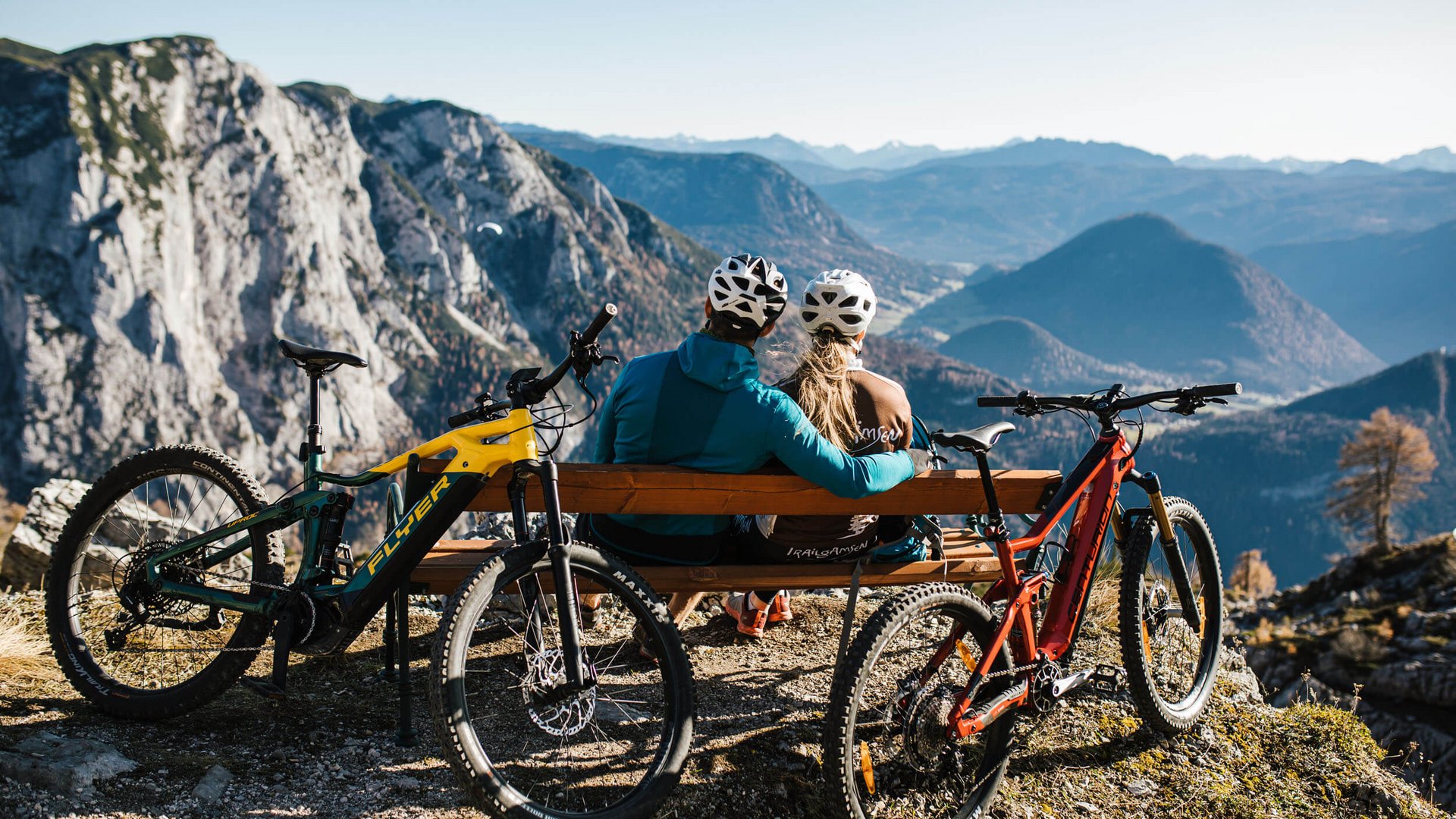 Mountainbike Urlaub für Anfänger
© TVB Ausseerland Salzkammergut - Katrin Kerschbaumer Zwei Radfahrer schauen von Bank auf Berglandschaft mit zwei Mountainbikes