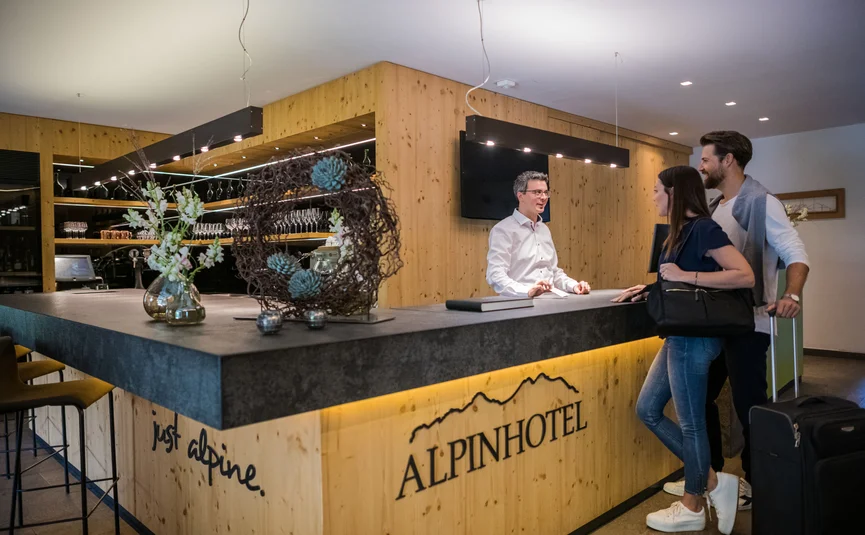 Couple checking in at the reception of the Alpinhotel