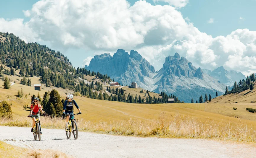Twee fietsers op een pad met bergen op de achtergrond