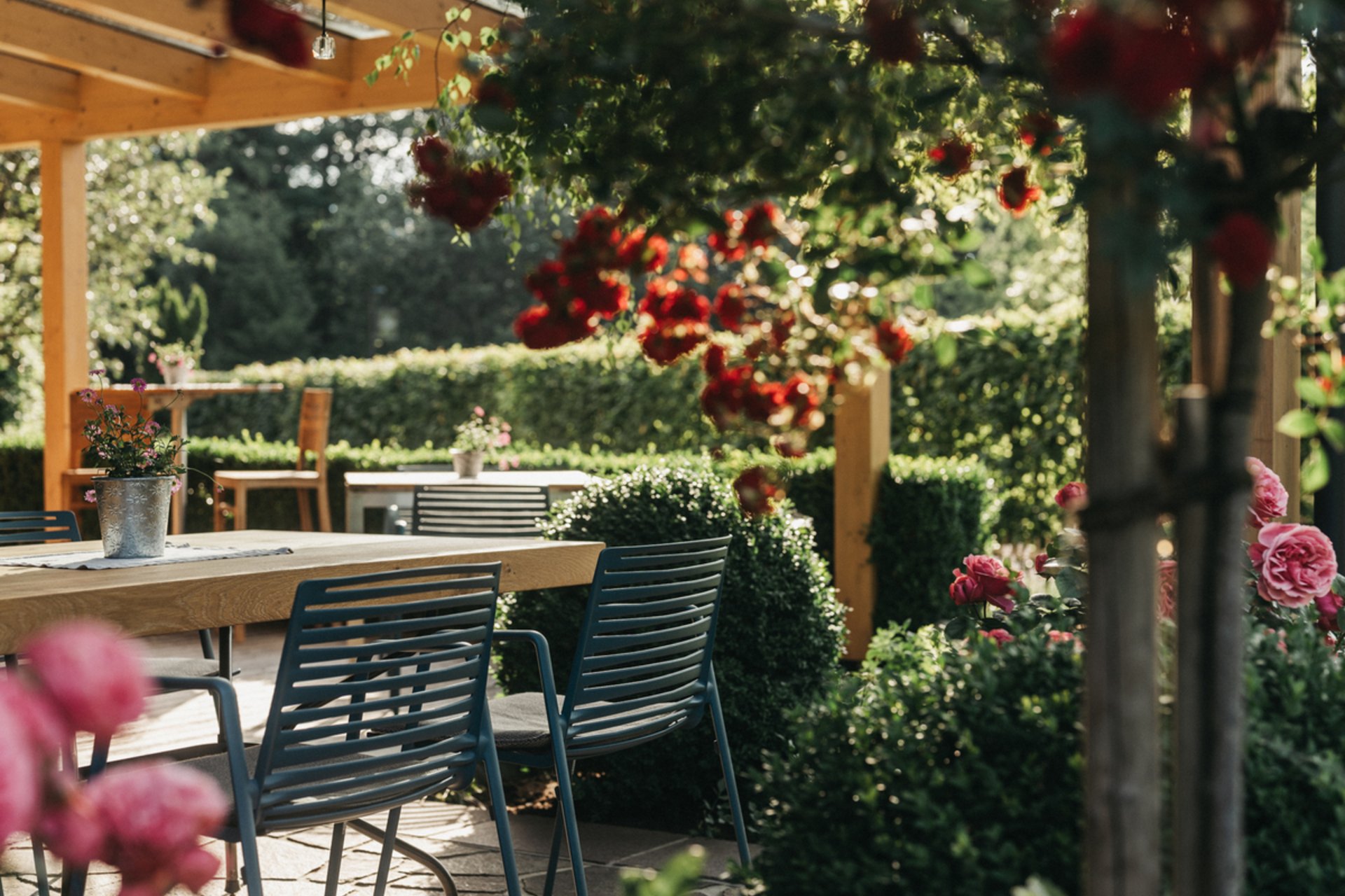 Gemütlicher Gartenbereich mit Holztisch und Stühlen unter Pergola