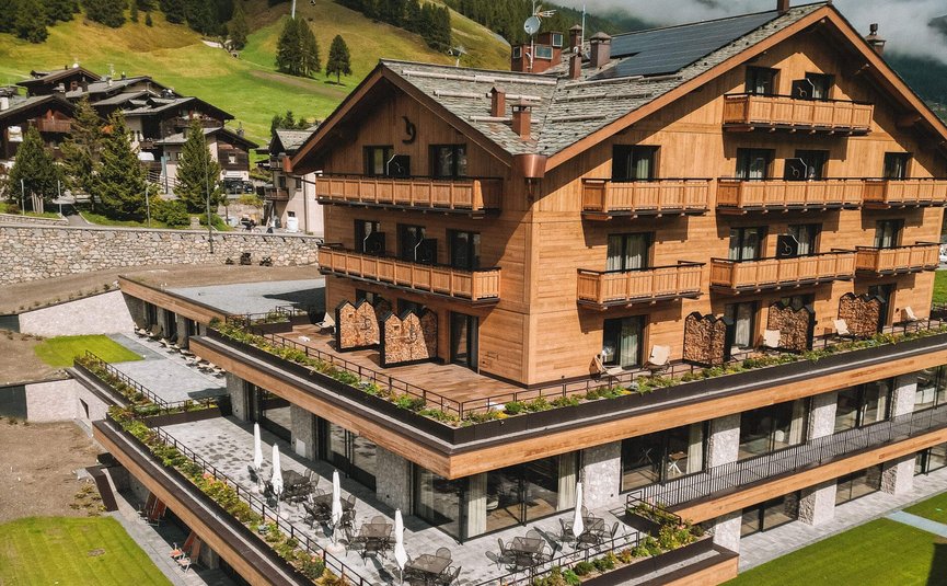 Paradise Lodge ****S Modern wooden hotel with pool and green mountains in the background