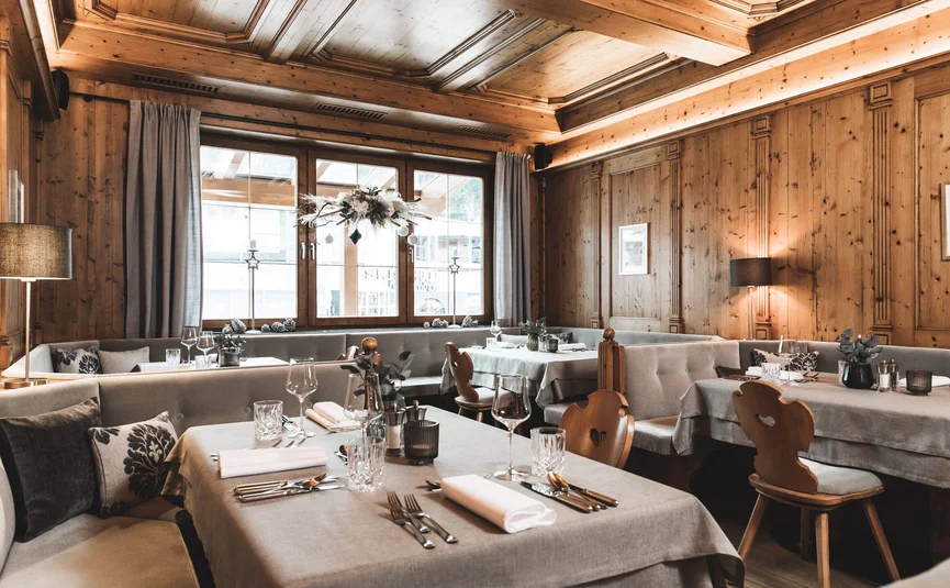 Gemütlicher Restaurantbereich mit Holzwänden und gedeckten Tischen