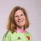 Lachende vrouw in mountainbike shirt en spijkerbroek voor lichte achtergrond