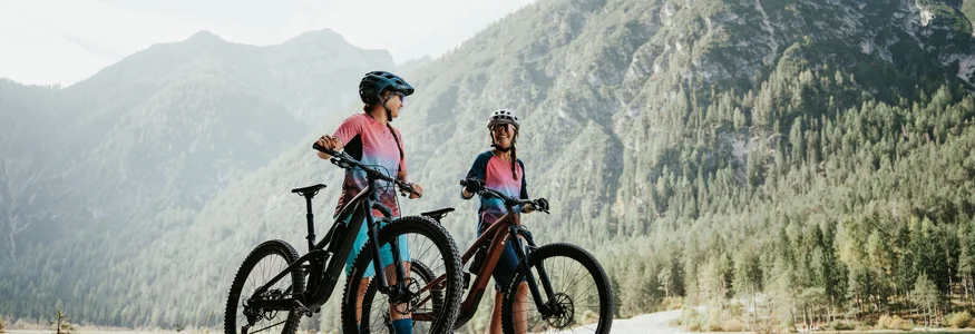 3 Zinnen Dolomites © Desire Lines - Tobias Dörr Zwei Radfahrer in bunter Kleidung mit Helmen vor Berglandschaft