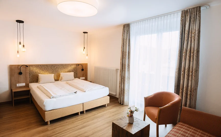 Helles modernes Schlafzimmer mit Doppelbett und gemütlicher Sitzecke