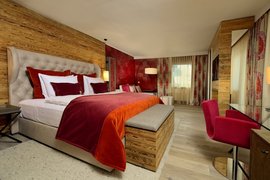 Moderne hotelkamer met een gezellig bed en rode inrichting