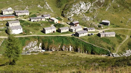 Small mountain village with stone and wooden houses in a green mountain landscape